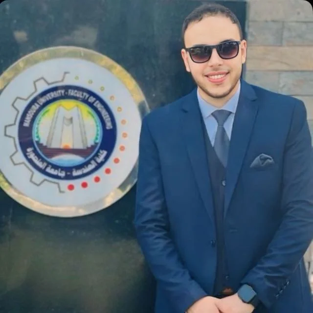 A portrait of the tutor in a blue blazer, standing beside an institutional emblem.