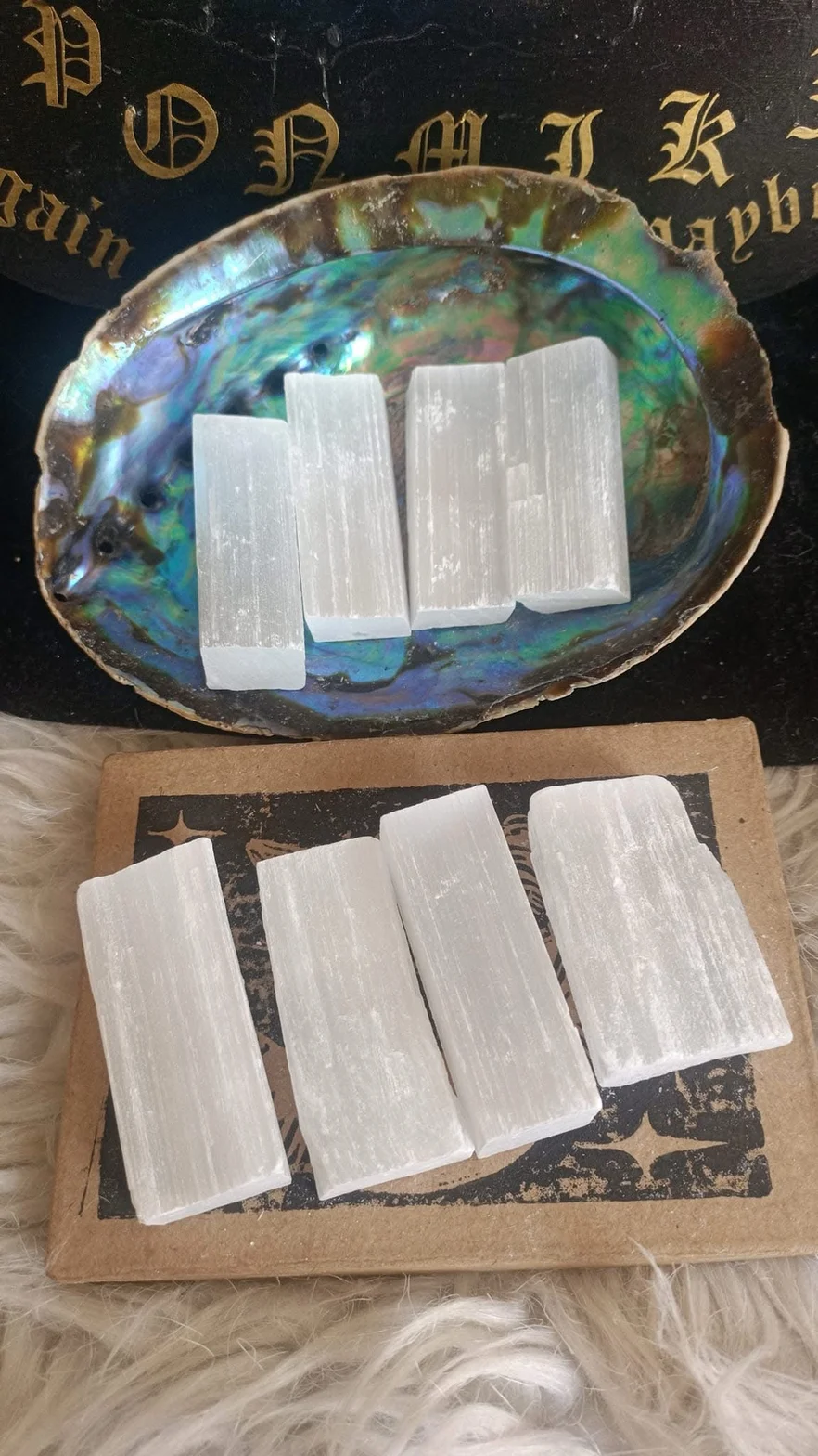 Witte selenietstaven in een iriserende schelp op een decoratieve ondergrond