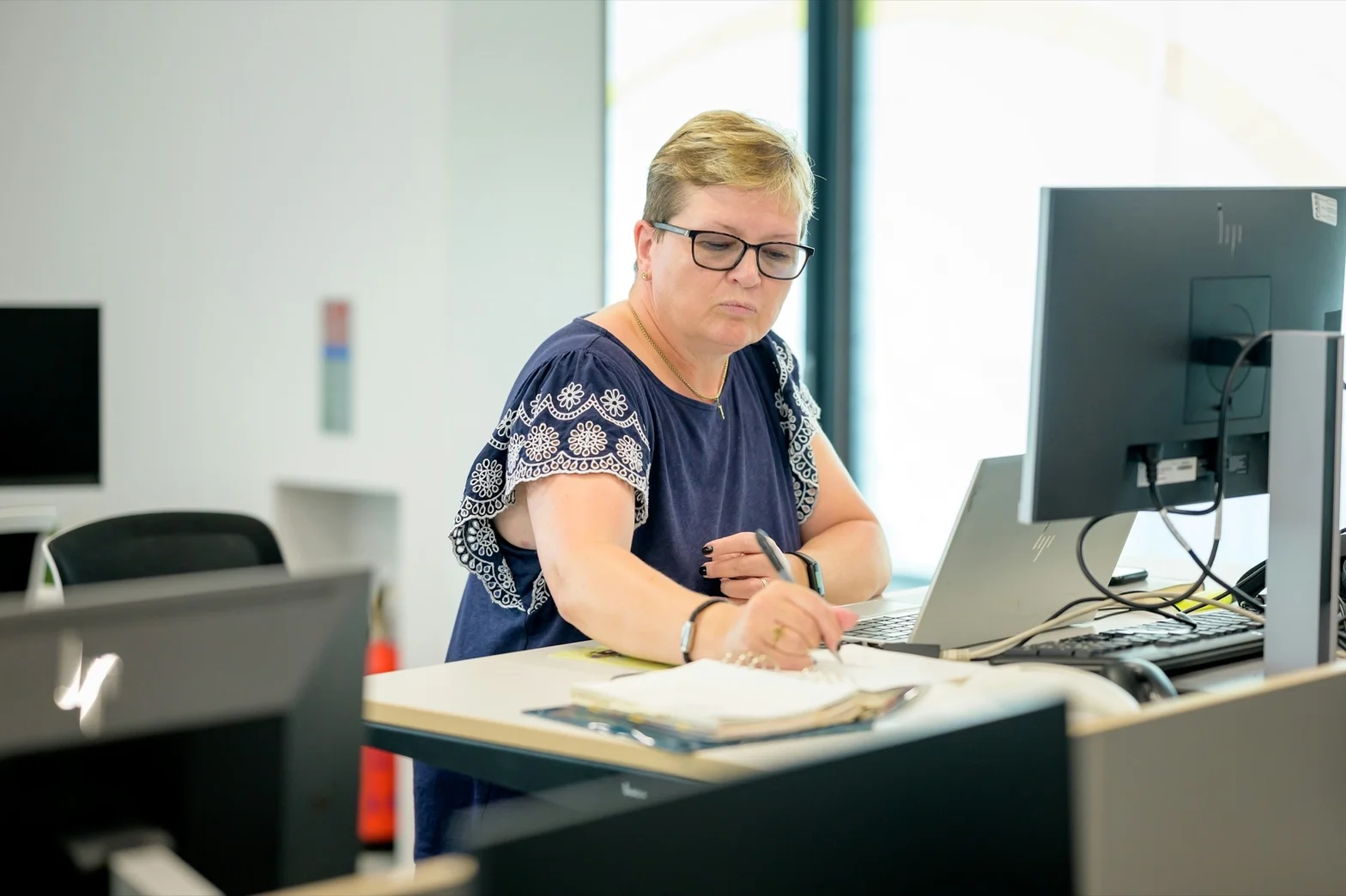 Clearline bookkeeper working at desk in Reading with laptop and monitors