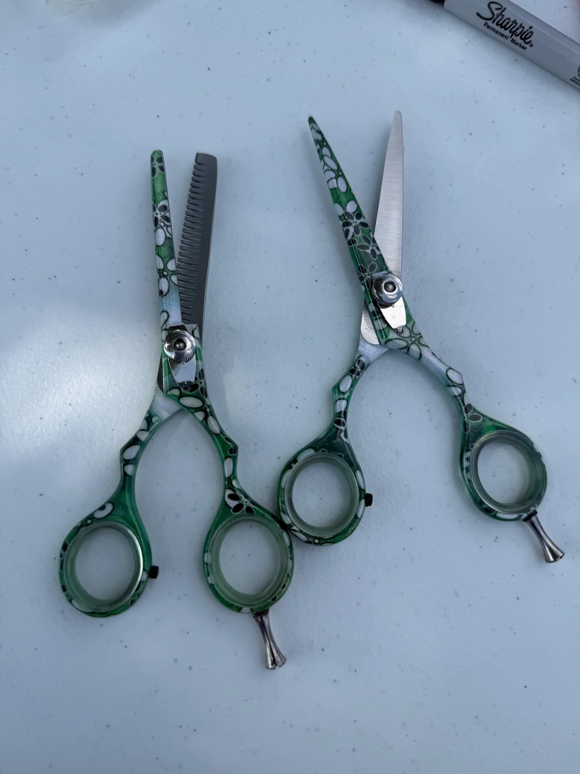 Green professional hair shears featuring precision cutting blades and tension dial