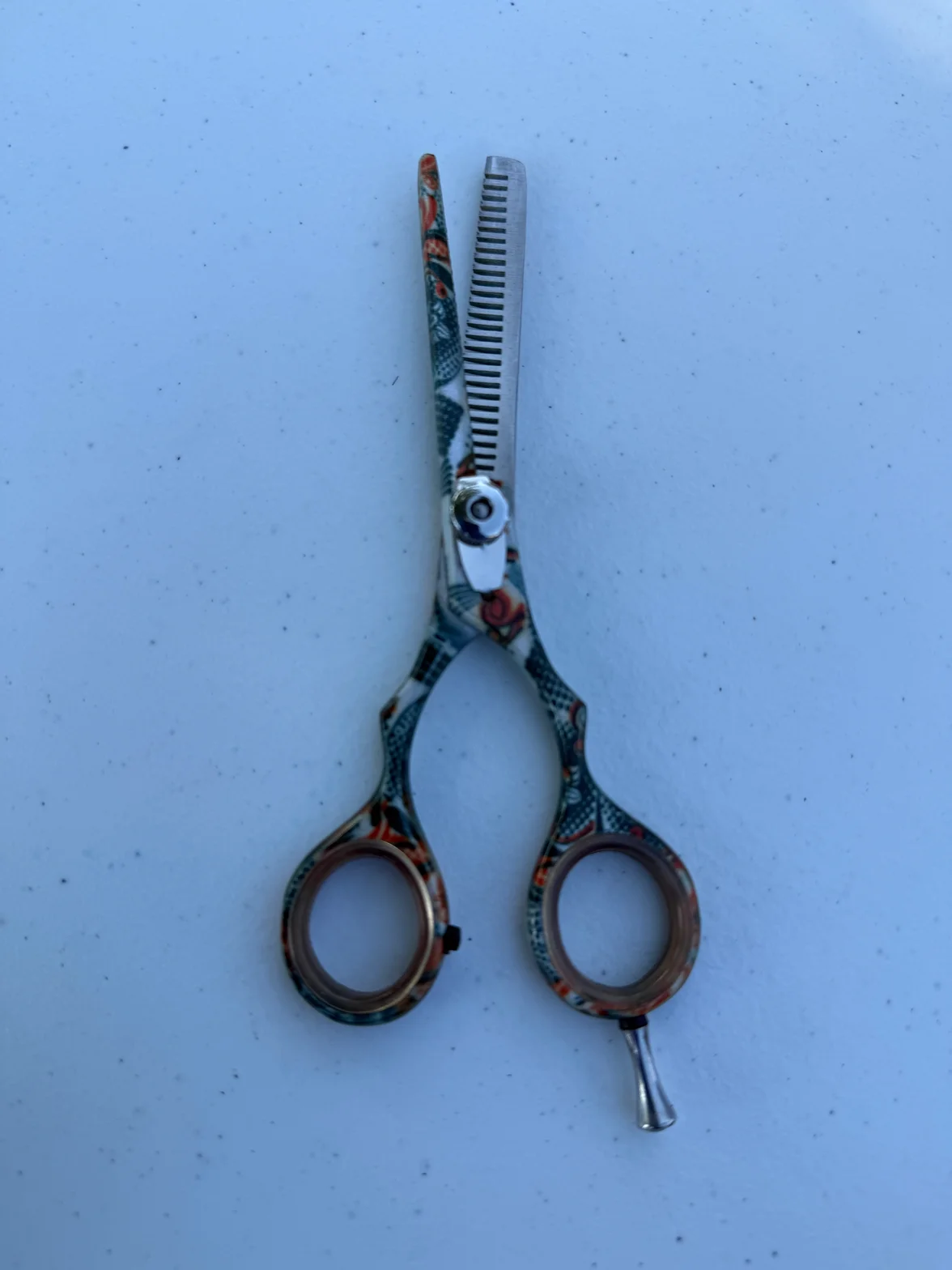 Patterned hair scissors with custom engraved handle design and precision blade