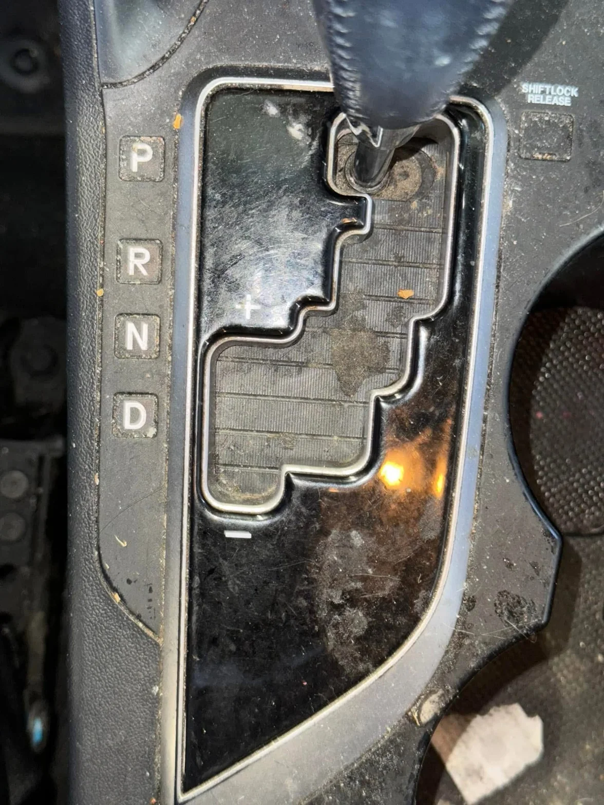 Close-up of a dirty automatic car gear selector and center console before detailing
