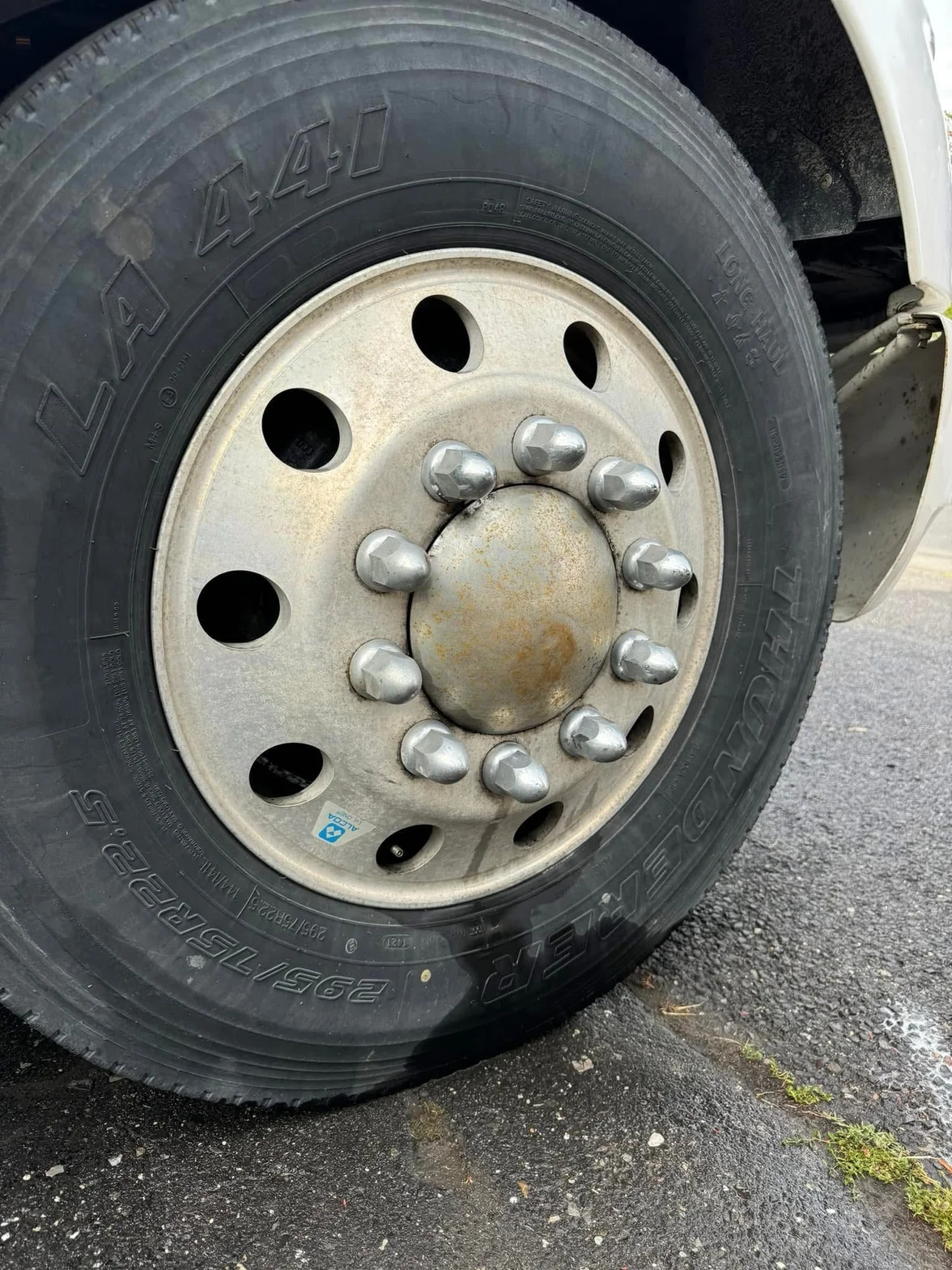 Close-up of a heavy-duty truck tire and metal wheel before cleaning and decontamination