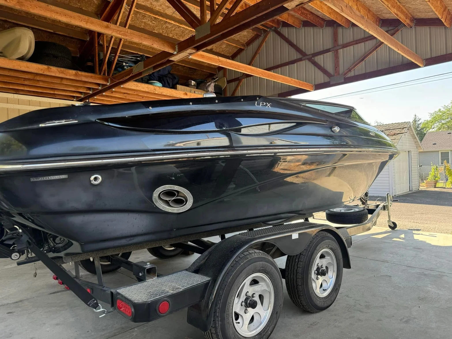 Glossy dark blue LPX speedboat on a trailer showing deep finish and marine detailing
