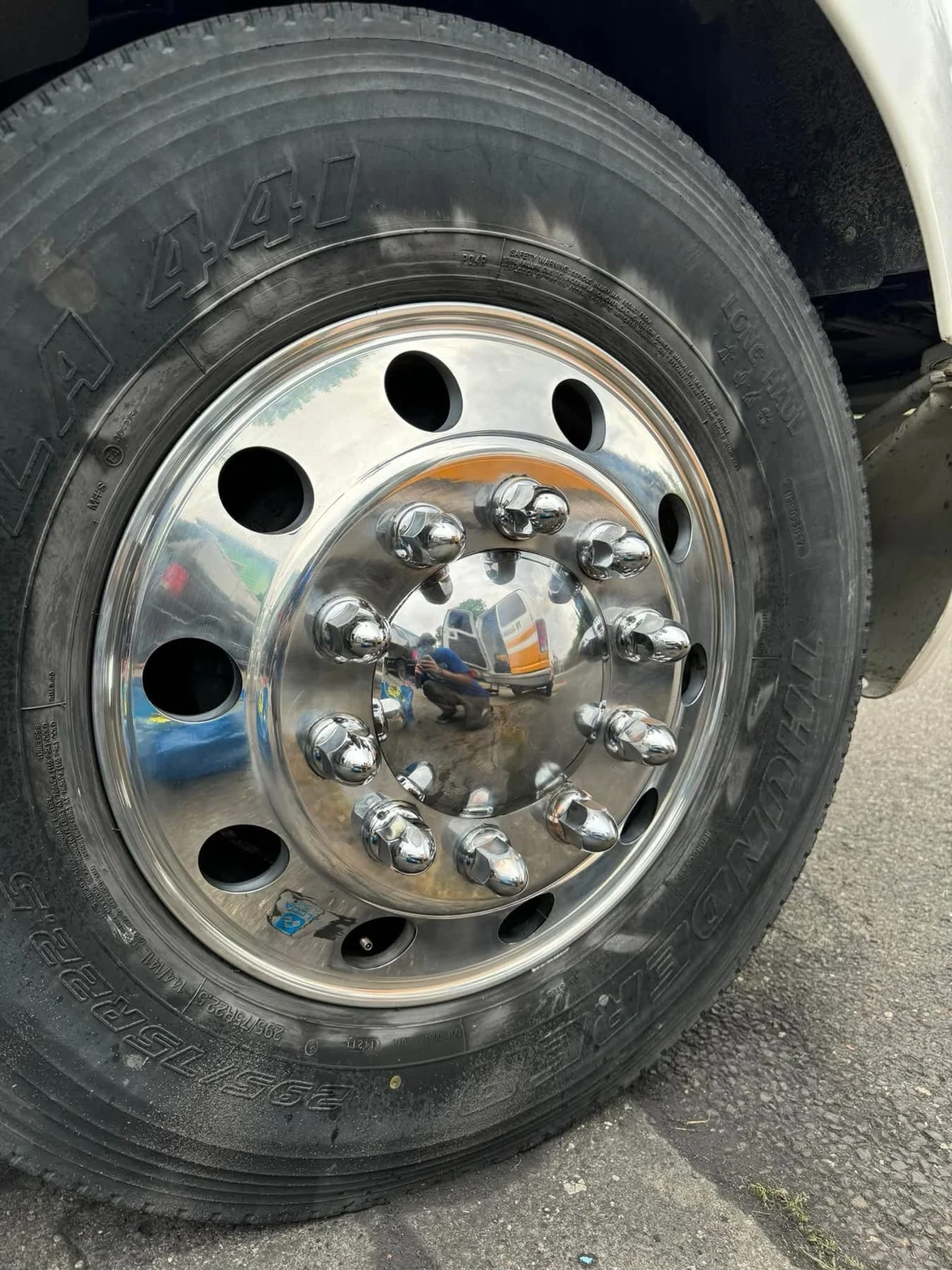 Close-up of a polished chrome wheel and clean tire finish reflecting the surroundings