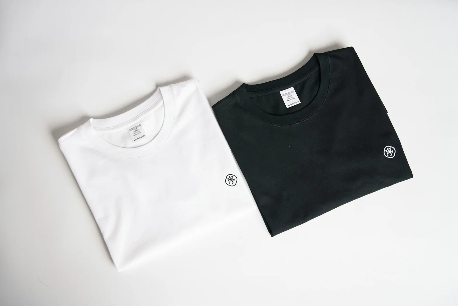 Folded black and white crew-neck T-shirts side by side